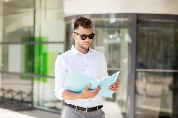 Young man with business file on city street — Stock Photo, Image