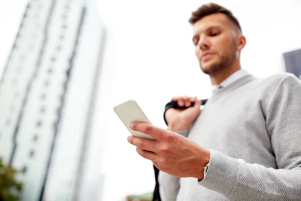 Primer plano del hombre mensajes de texto en el teléfono inteligente en la ciudad — Foto de Stock