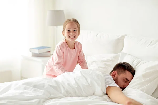 Küçük kız yatakta uyuyan babası uyanma — Stok fotoğraf