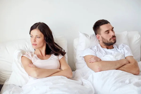 Ulykkelig par som har en konflikt i sengen hjemme – stockfoto