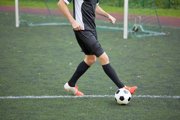 Fußballer spielt mit Ball auf Fußballplatz — Stockfoto