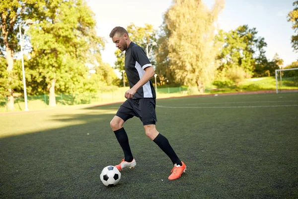 Jugador de fútbol jugando con pelota en el campo de fútbol —  Fotos de Stock