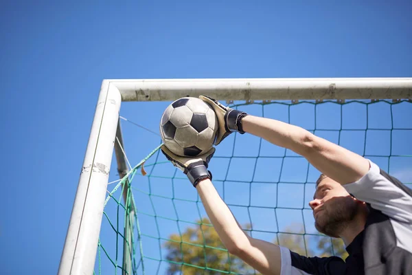 Goalkeeper with ball at football goal on field — Stock Photo, Image