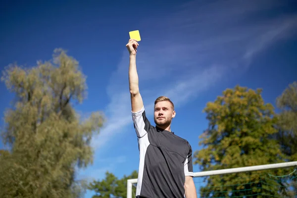 Referee on football field showing yellow card — Stock Photo, Image
