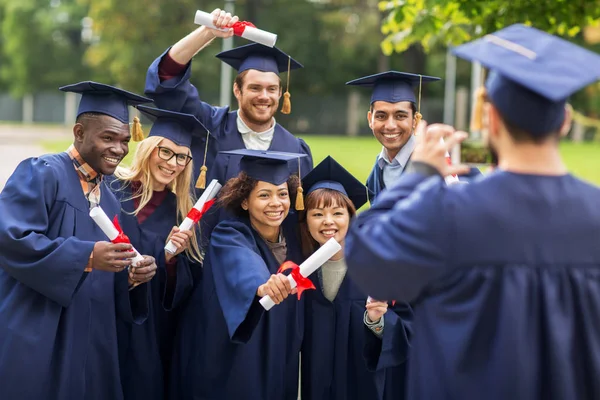 Students or bachelors photographing by smartphone — Stock Photo, Image