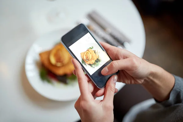 Mujer con smartphone fotografiando comida en la cafetería — Foto de Stock