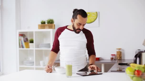朝食を家で食べるタブレット pc を持つ男 — ストック動画