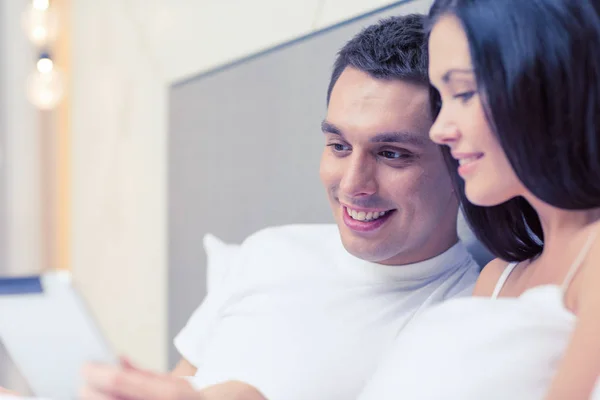 Χαμογελώντας ζευγάρι στο κρεβάτι με τα tablet pc υπολογισ — Φωτογραφία Αρχείου