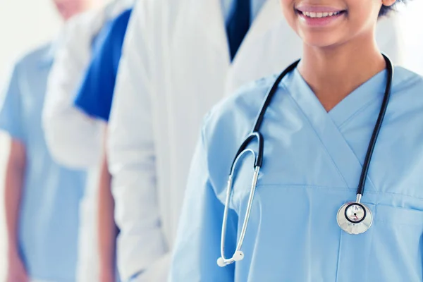 Perto de médico feliz ou enfermeira com estetoscópio — Fotografia de Stock