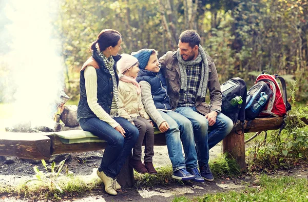 Šťastná rodina sedí na lavičce a mluví v táboře — Stock fotografie