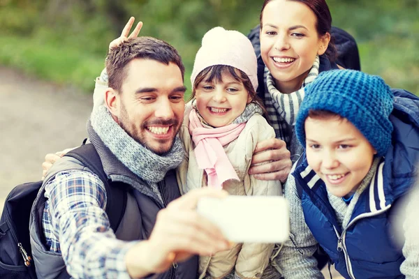 Família tomando selfie com smartphone na floresta — Fotografia de Stock
