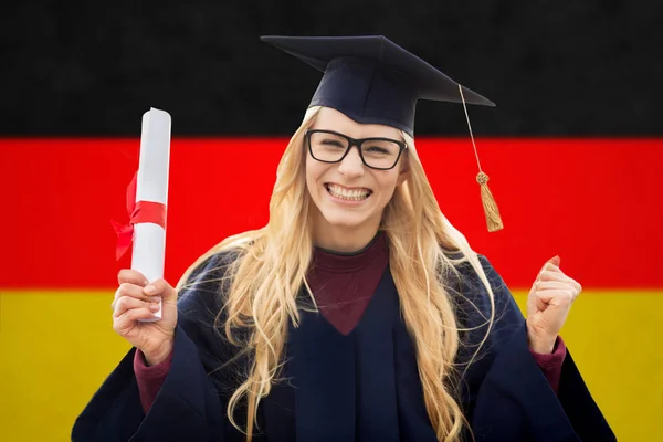 Happy female student with diploma over german flag — Stock Photo, Image