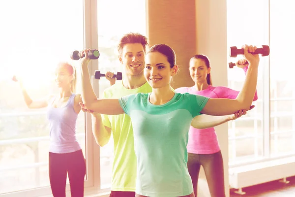 Group of smiling people exercising with dumbbells — Stock Photo, Image