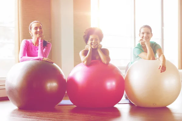 Grupo de mujeres sonrientes con bolas de ejercicio en el gimnasio — Foto de Stock