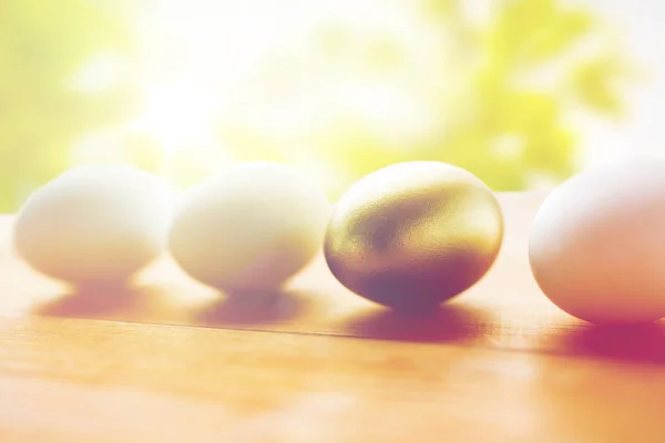 Close up of golden and white easter eggs on wood — Stock Photo, Image