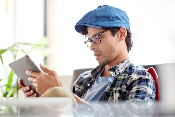 Man met tablet pc zitten aan Cafe tafel — Stockfoto