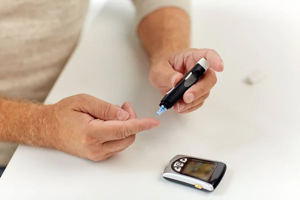 Senior man with glucometer checking blood sugar — Stock Photo, Image