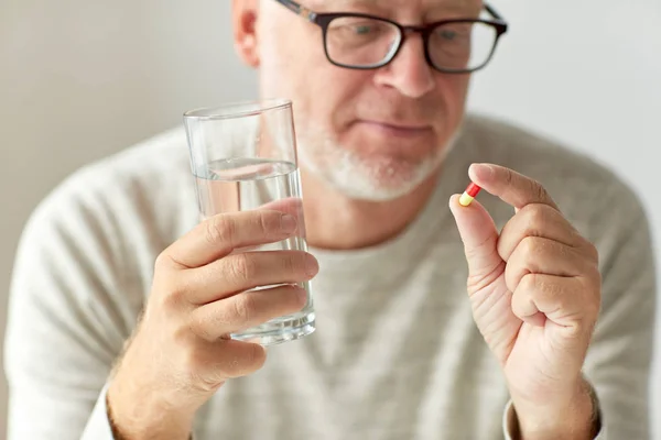 Close up of hands with medicine pills and water — Stock Photo, Image