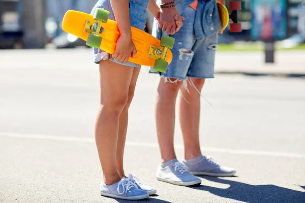 Close up de jovem casal com skates na cidade — Fotografia de Stock