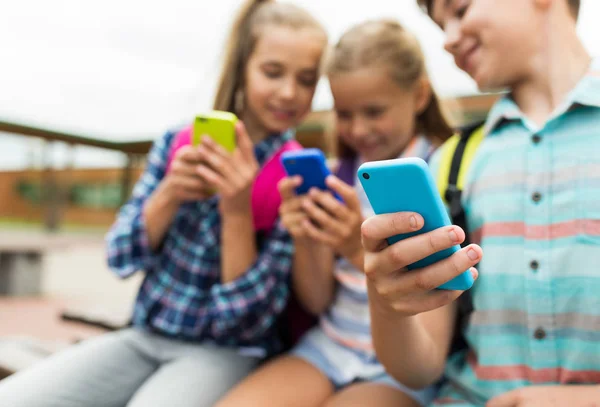 Alunos do ensino fundamental com smartphones — Fotografia de Stock