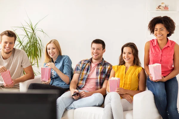 Glada vänner med popcorn på tv hemma — Stockfoto