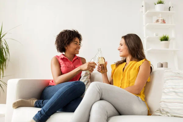 Gelukkig vrouwen rammelende flessen bier thuis — Stockfoto