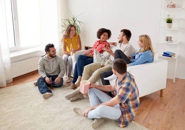 Amigos felices con palomitas de maíz y cerveza en casa — Foto de Stock