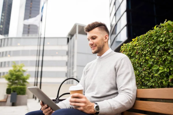 Hombre con la tableta PC y café en el banco de la calle de la ciudad — Foto de Stock