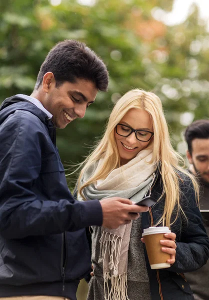 Glada vänner med smartphone och kaffe utomhus — Stockfoto