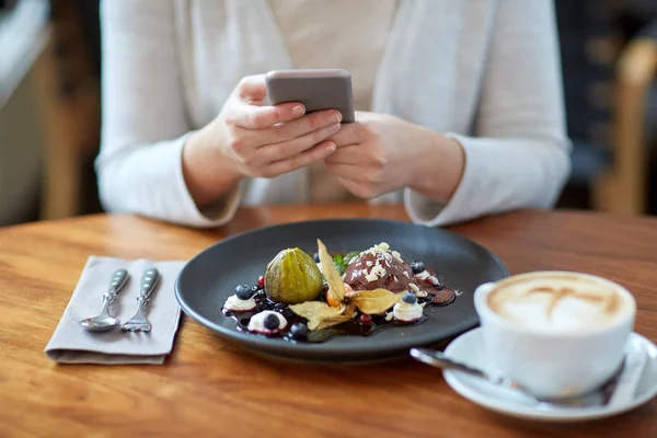 Femeie cu smartphone-uri care fotografiază mâncare la cafenea — Fotografie, imagine de stoc