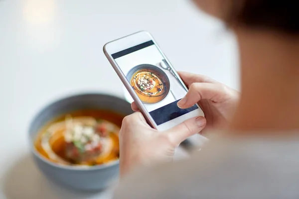 Kobieta z smartphone fotografowania żywności w kawiarni — Zdjęcie stockowe