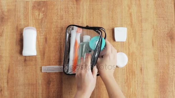 Manos embalaje bolsa de cosméticos para viajar — Vídeo de stock