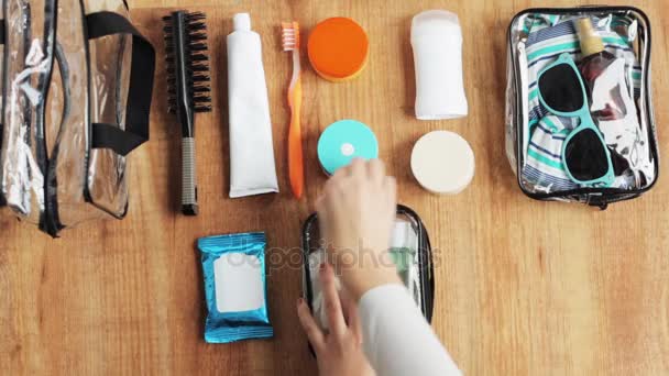 Manos embalaje bolsa de cosméticos con cosas para viajar — Vídeo de stock