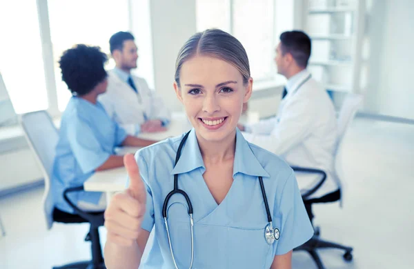 Zufriedener Arzt über Gruppe von Sanitätern im Krankenhaus — Stockfoto