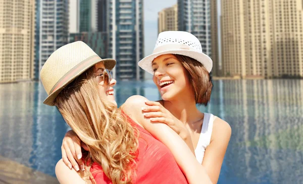 Gelukkig jonge vrouwen in hoeden op zomer-strand — Stockfoto