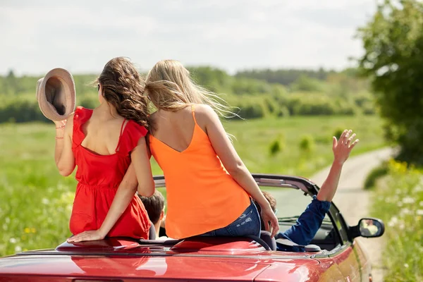 Amigos felizes dirigindo em carro cabriolet no país — Fotografia de Stock