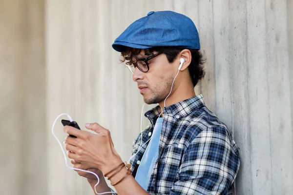 Homem com fones de ouvido e smartphone ouvindo música — Fotografia de Stock