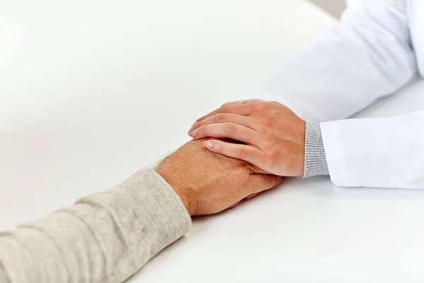 Nahaufnahme eines Arztes, der einem alten Mann die Hand hält — Stockfoto