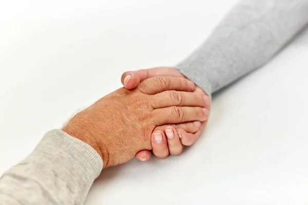 Primer plano de hombre viejo y mujer joven tomados de la mano — Foto de Stock