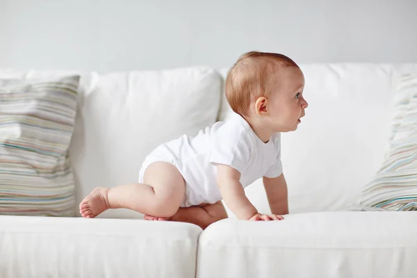 Kis baba pelenka mászik végig kanapé otthon — Stock Fotó