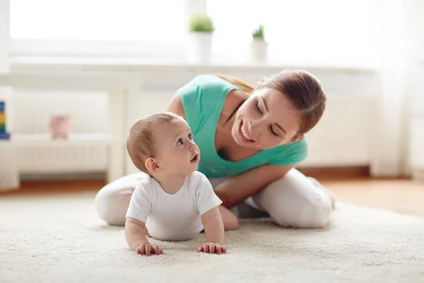 Mãe feliz brincando com o bebê em casa — Fotografia de Stock