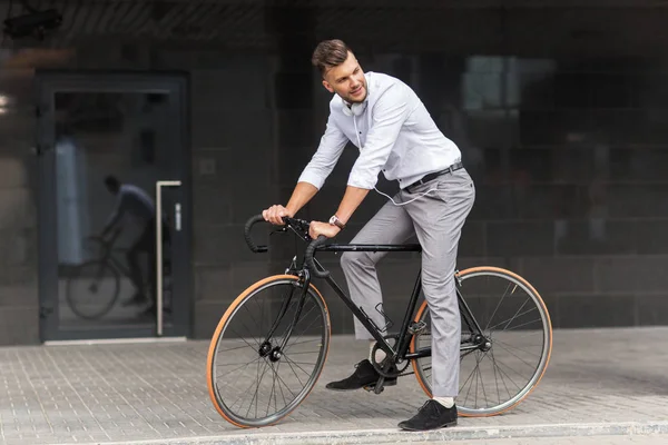 Hombre con bicicleta y auriculares en la calle de la ciudad — Foto de Stock