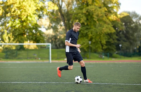 Voetbalspeler met bal op voetbalveld spelen — Stockfoto