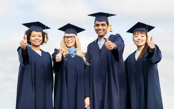 Happy students or bachelors showing thumbs up — Stock Photo, Image