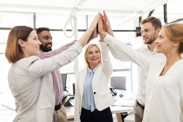 Glada affärsteam gör high five på kontoret — Stockfoto