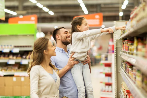 Familia feliz comprando comida en la tienda de comestibles —  Fotos de Stock
