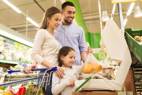 Família de laranjas de pesagem em escala no supermercado — Fotografia de Stock