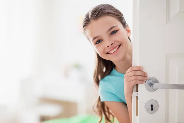 Glücklich lächelnd schöne Mädchen hinter der Tür zu Hause — Stockfoto
