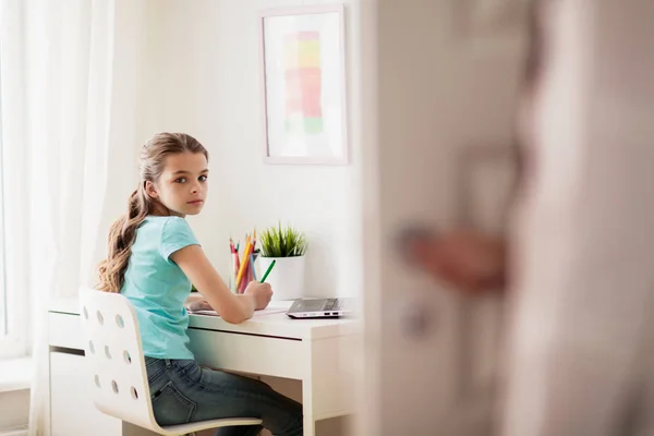 Chica con la escritura del ordenador portátil a la libreta en casa — Foto de Stock