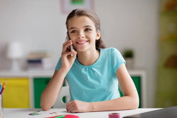 Menina feliz chamando no smartphone em casa — Fotografia de Stock